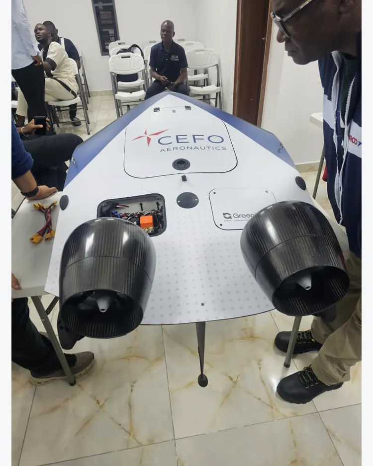 CEFO-branded aircraft indoors with two black ducted fans and people alongside it